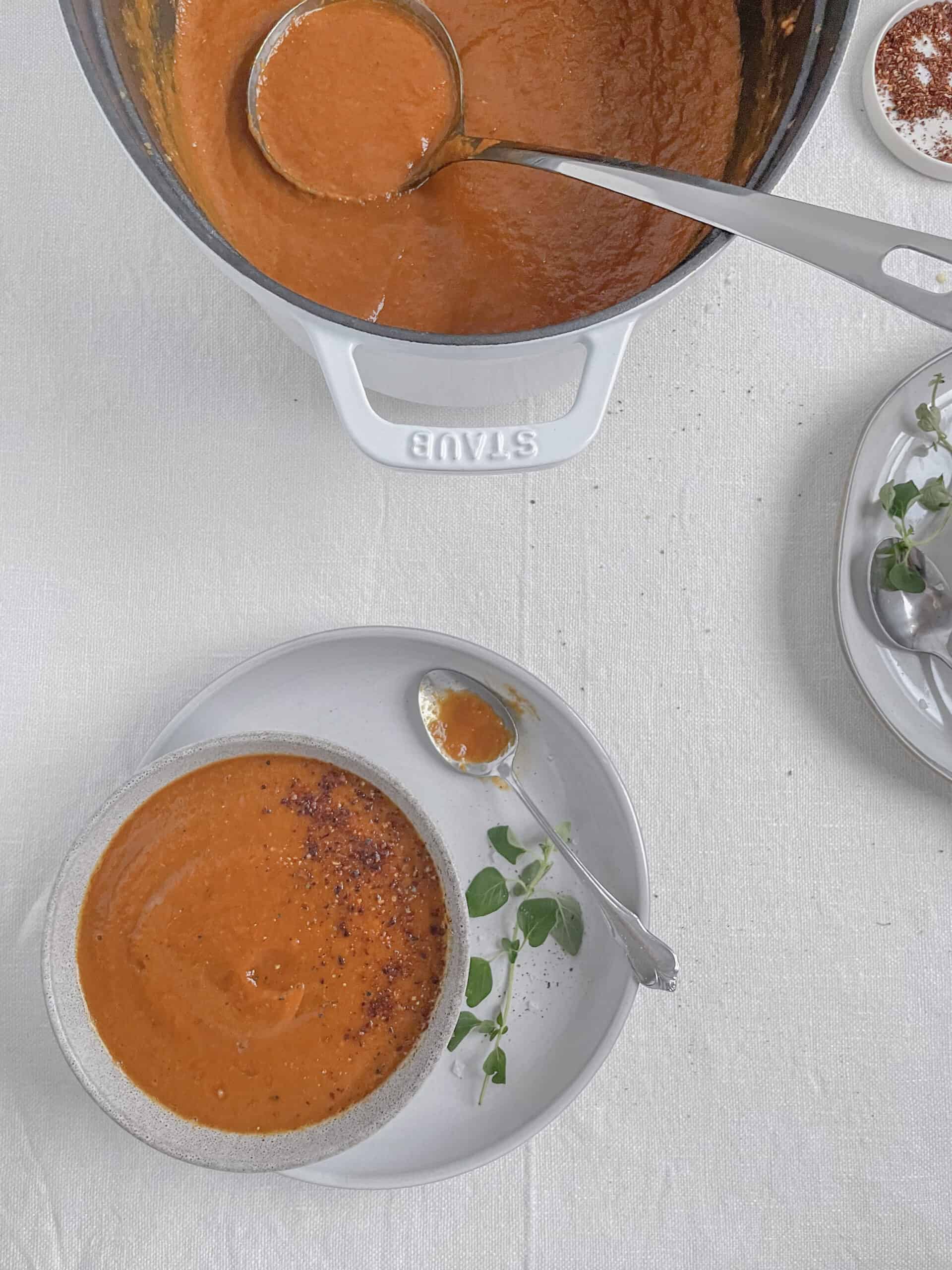 tomato soup in small bowls with fresh oregano.