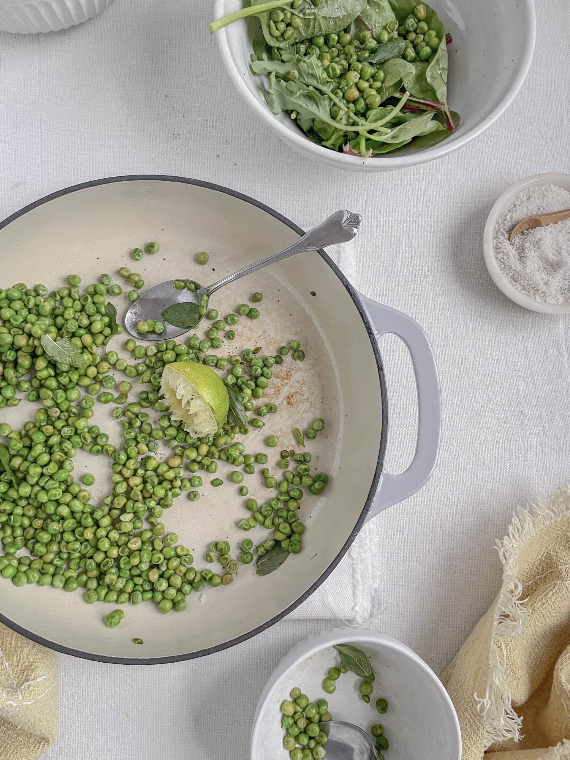 table setting of sauteed peas with serving plates