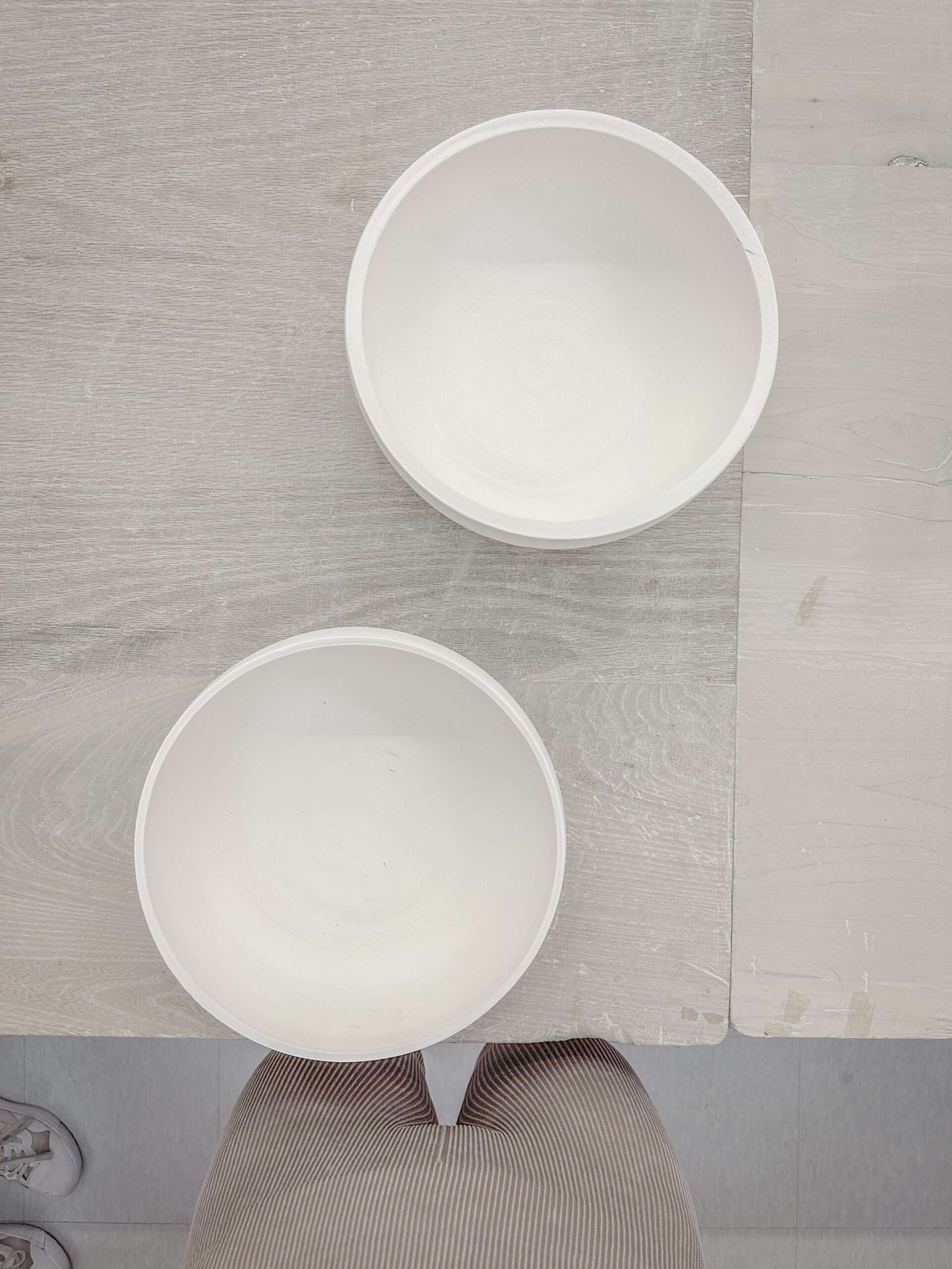 two pottery bowls bisque fired on a large table